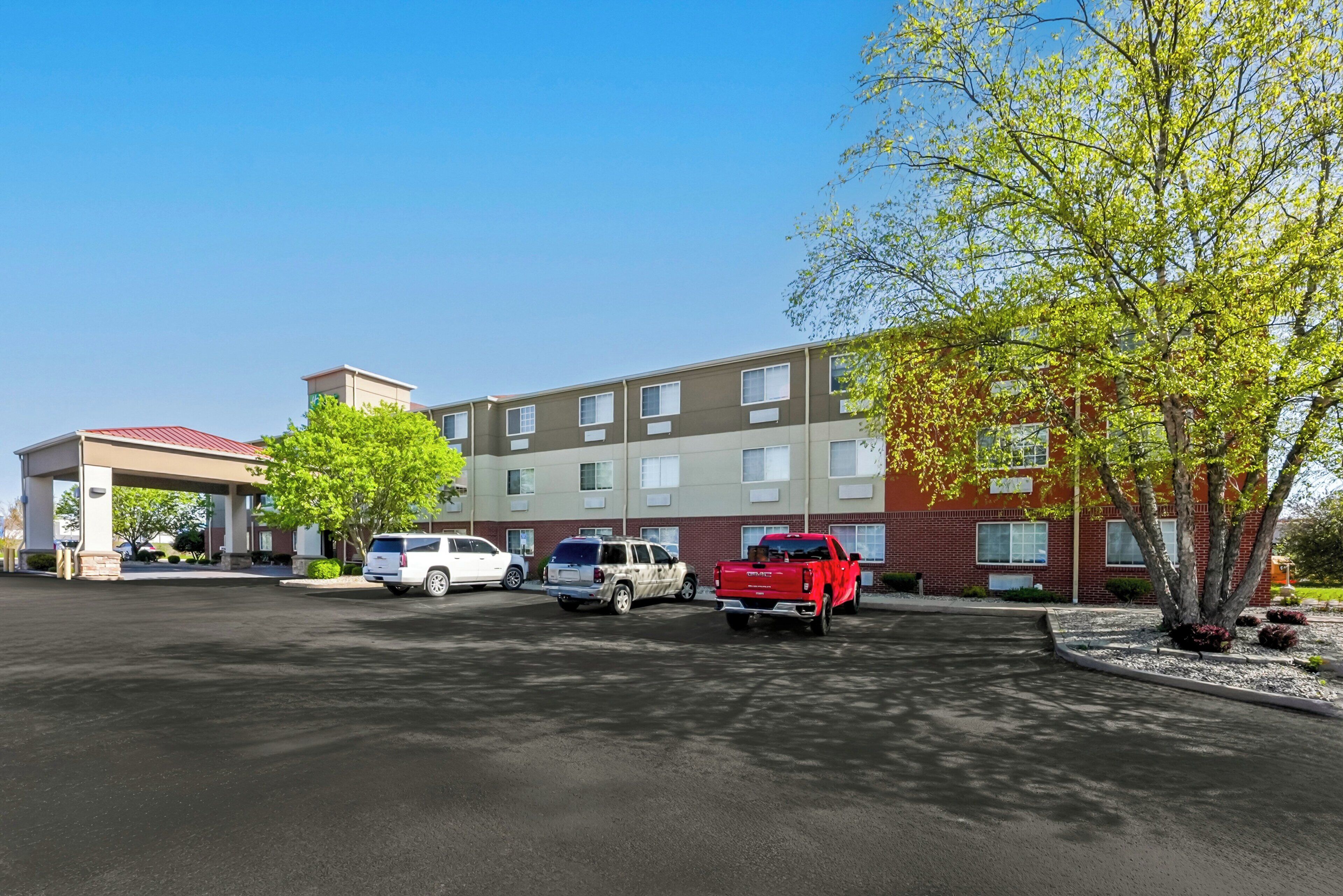 A hotel with a parking lot, a gas station, and a red pickup truck.