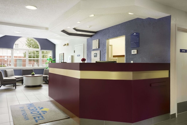 A reception area with a reception desk, seating area, and a view of the outside. - Microtel Inn by Wyndham Louisville East (Louisville)