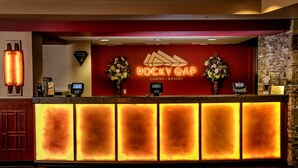 A reception desk at Rocky Gap Casino & Resort with a red backdrop, two flower arrangements, and a 'VIP Services' mat. - Rocky Gap Casino & Resort (Cumberland)