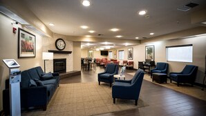 Un hall d’entrée spacieux avec une cheminée, un coin salon et un kiosque numérique.