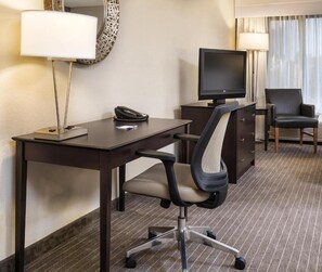 A hotel room with a desk, chair, TV, and a lamp. - Holiday Inn Express St Paul S - Inver Grove Hgts by IHG (Inver Grove Heights)