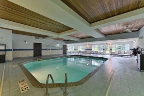 A swimming pool with a wooden ceiling, clear poolside area, and a view of the outdoors through large windows. - Holiday Inn Express St Paul S - Inver Grove Hgts by IHG (Inver Grove Heights)