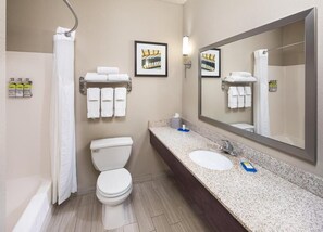 A bathroom with a toilet, sink, and shower. There are towels and toiletries on the wall. - Holiday Inn Express St Paul S - Inver Grove Hgts by IHG (Inver Grove Heights)