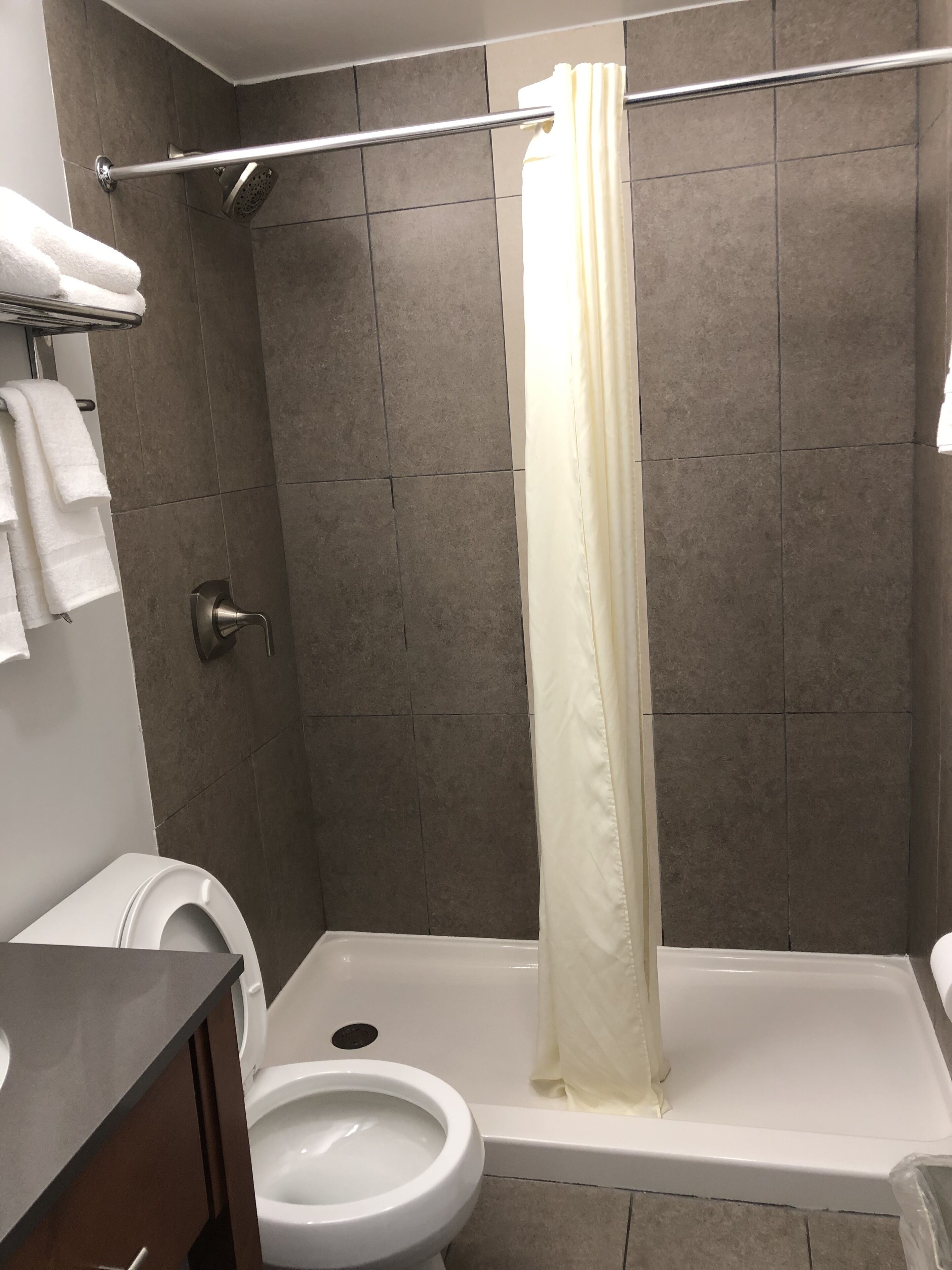 Un baño con ducha, inodoro y lavamanos.