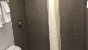 A bathroom with a shower, toilet, and sink.