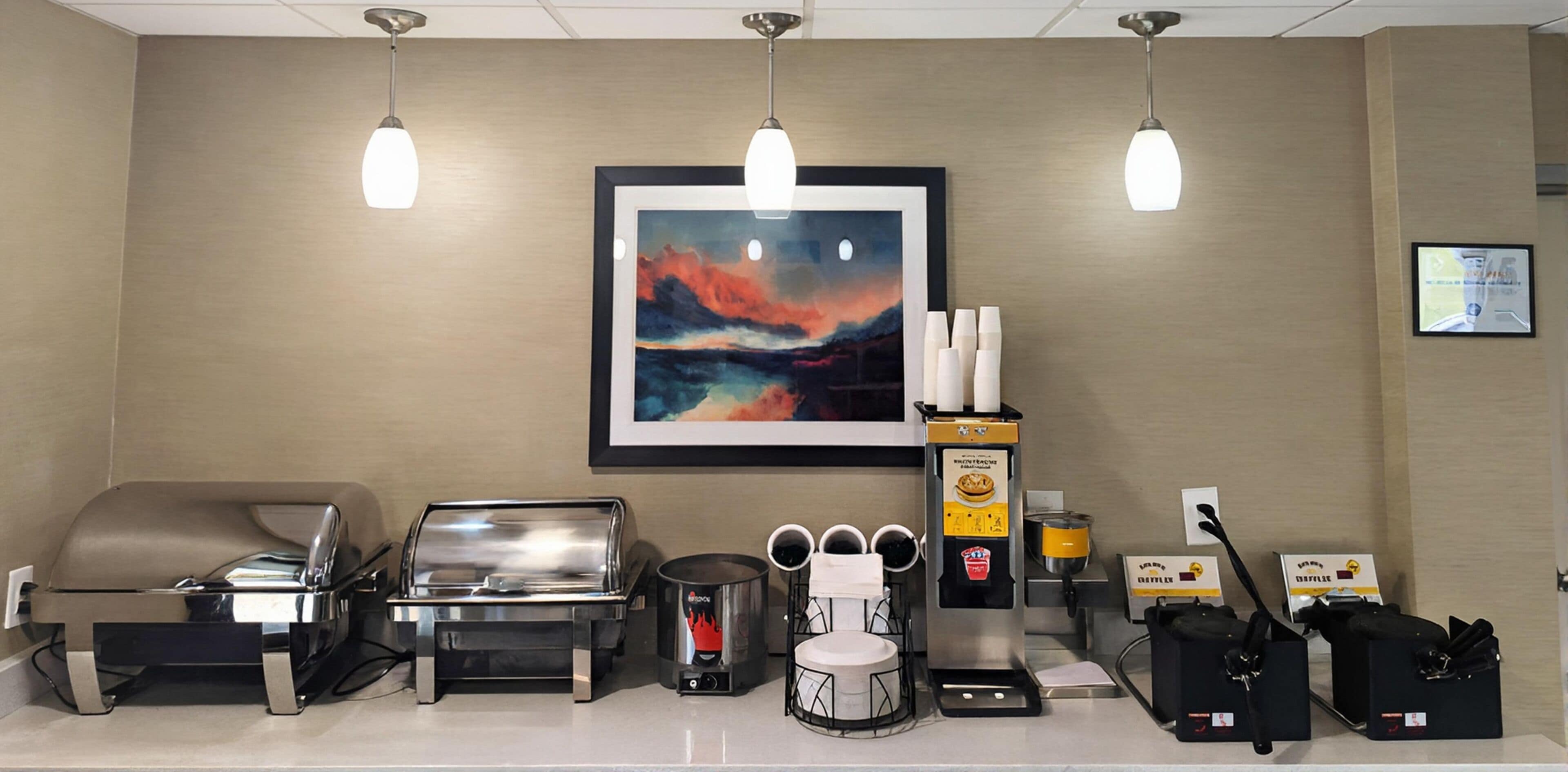Uma área de recepção de hotel com uma máquina de café, um espaço de estar e um quadro na parede.