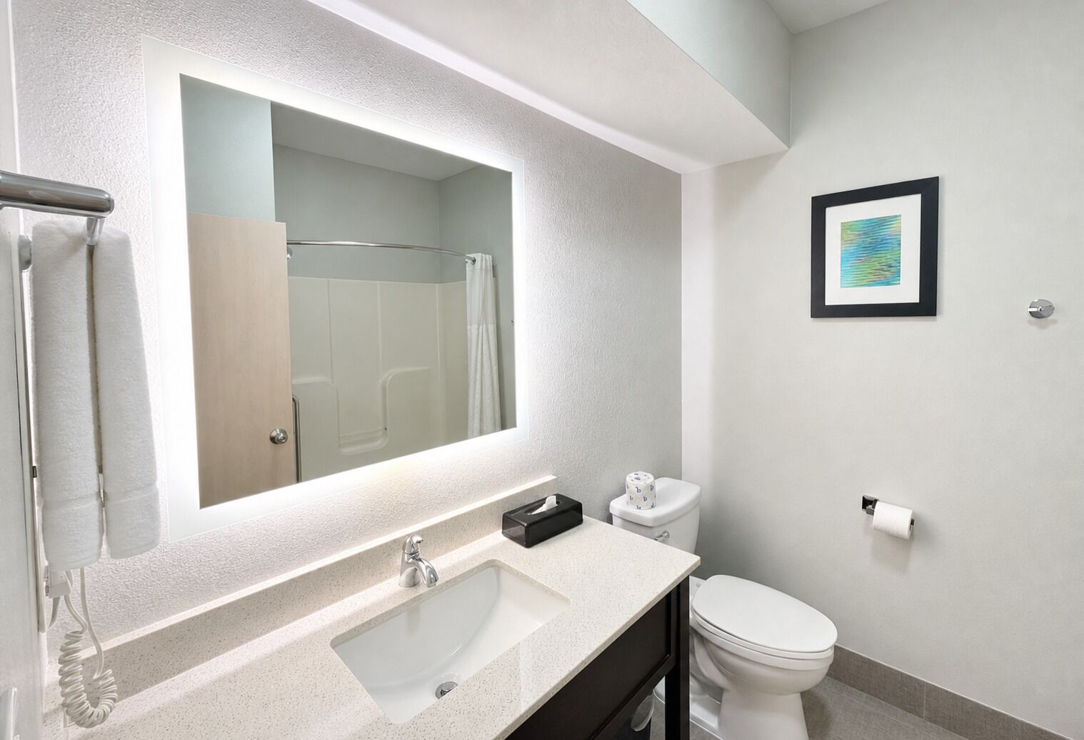 A modern bathroom with a large mirror, a sink, a toilet, and a shower.