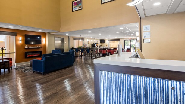 Un hall de hotel con mostrador de recepción, zona de estar y un bar.