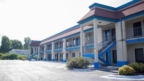 Un motel con varios pisos, estacionamiento exterior y una escalera central.