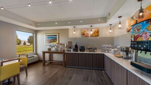 A modern kitchen with a large island, built-in appliances, and a view of the outdoors. - Comfort Inn & Suites Tipp City Dayton North I-75 (Tipp City)