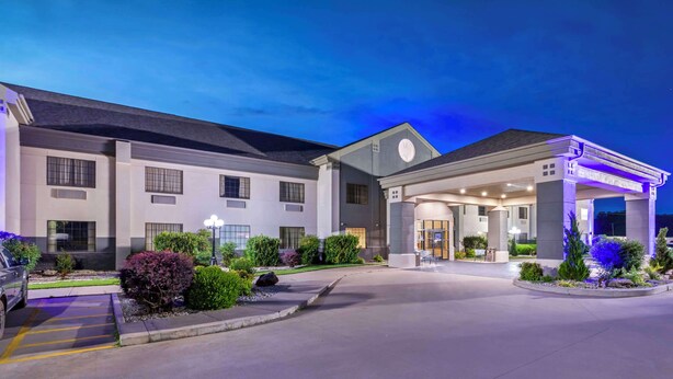 A hotel entrance with a covered driveway, a parking area, and landscaped gardens. - Best Western Locust Grove Inn & Suites (Locust Grove)