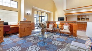 A spacious lobby with a high ceiling, wooden furniture, a glass coffee table, and a patterned carpet. - Best Western Locust Grove Inn & Suites (Locust Grove)