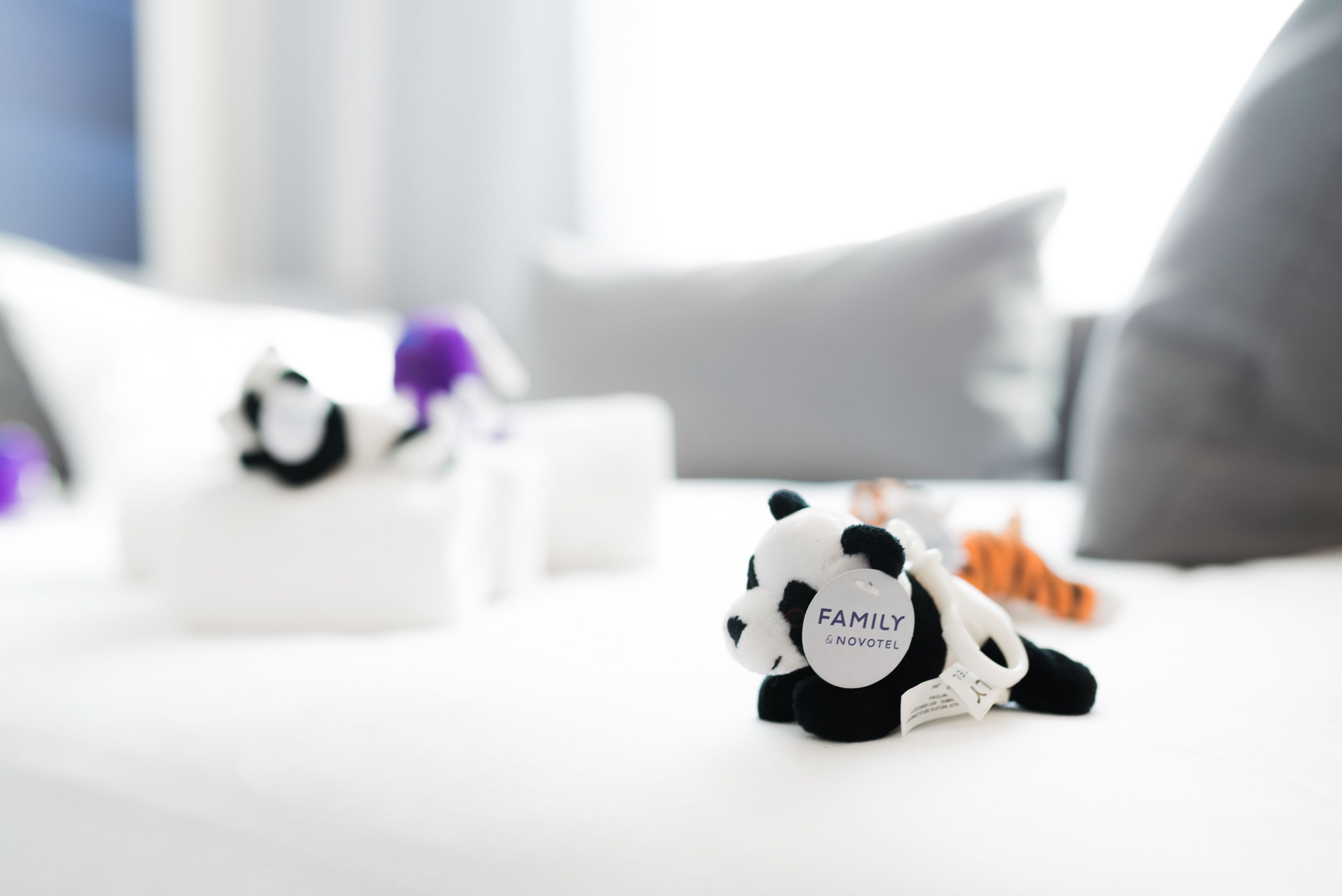 A bed with a small panda figurine labeled "FAMILY" and a tiger toy.