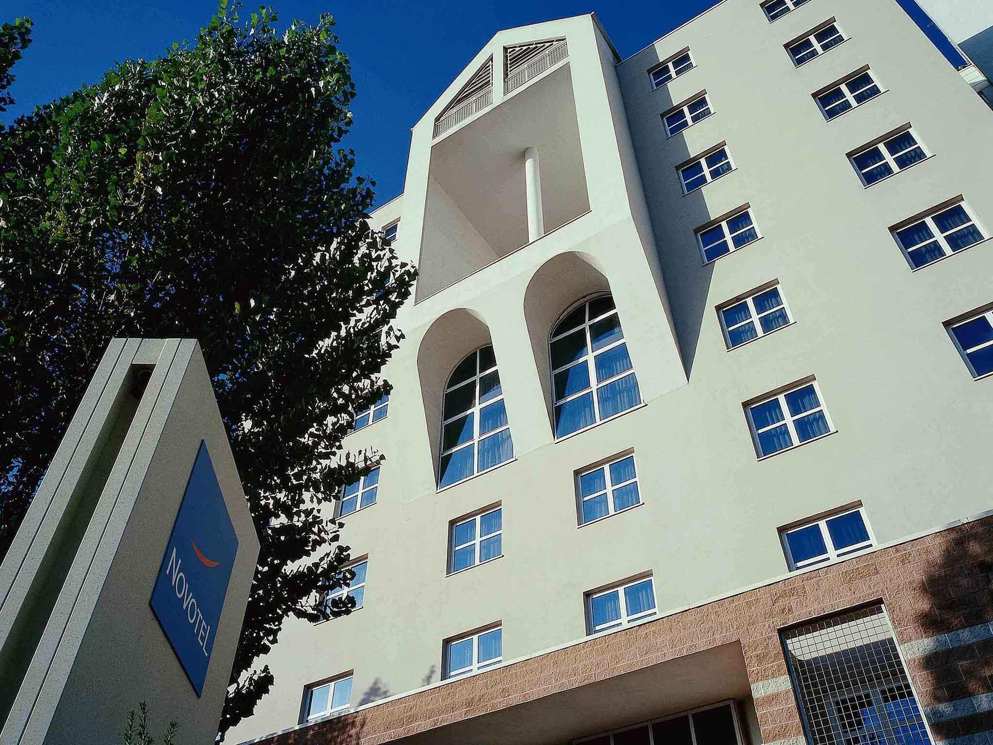 A multi-story building with a modern architectural style, featuring arched windows and a flat roof.