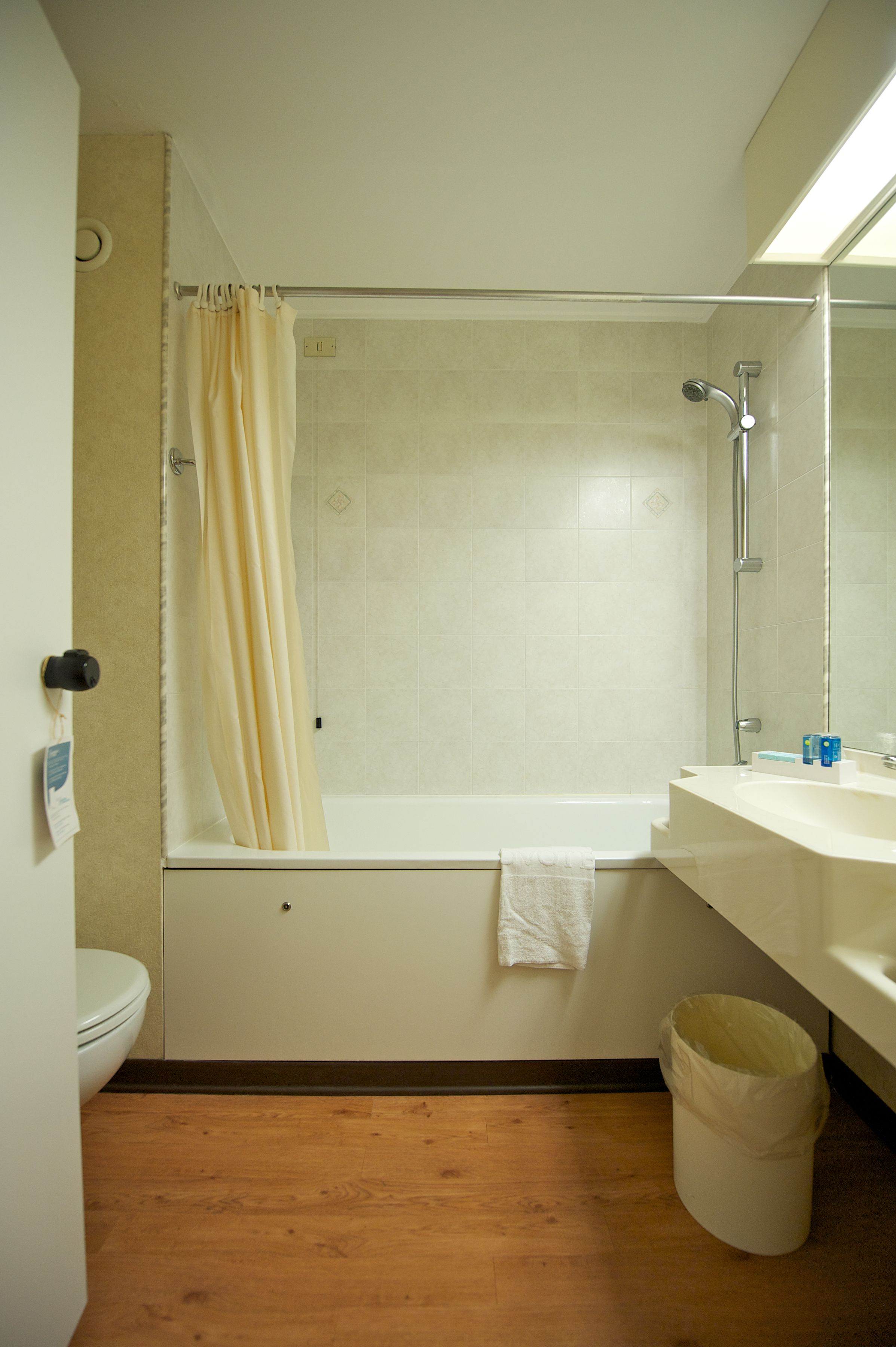 A bathroom with a shower, toilet, and sink.