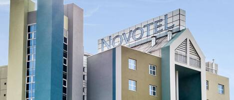 A hotel with a modern design, featuring a prominent 'NOVOTEL' sign on the top.