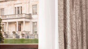 Una mesa con una bandeja de alimentos para el desayuno, un jarrón de tulipanes y vista a un edificio.