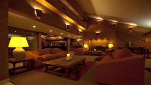 Ein gemütlich beleuchteter Lounge-Bereich mit Sofas, einem Couchtisch und stimmungsvoller Beleuchtung.
