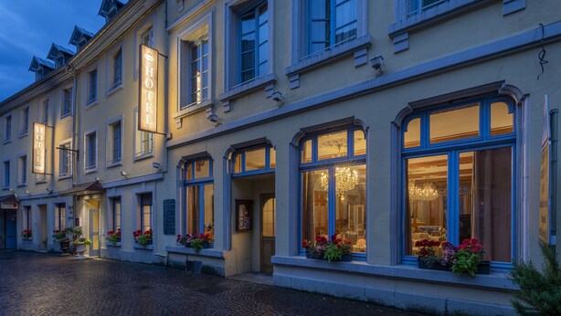 Un hotel histórico con arquitectura clásica, amplias ventanas y una entrada acogedora.