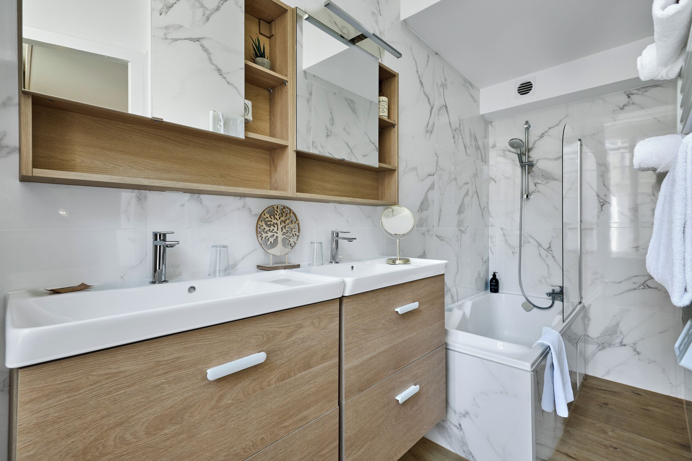 Een moderne badkamer met een marmeren achterwand, een houten wastafelmeubel en een inloopdouche.