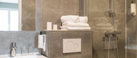 Un baño moderno con ducha, inodoro y lavamanos.