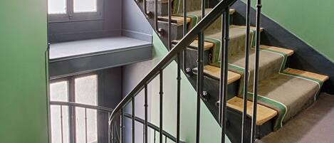 A spiral staircase with metal railings and carpeted steps.