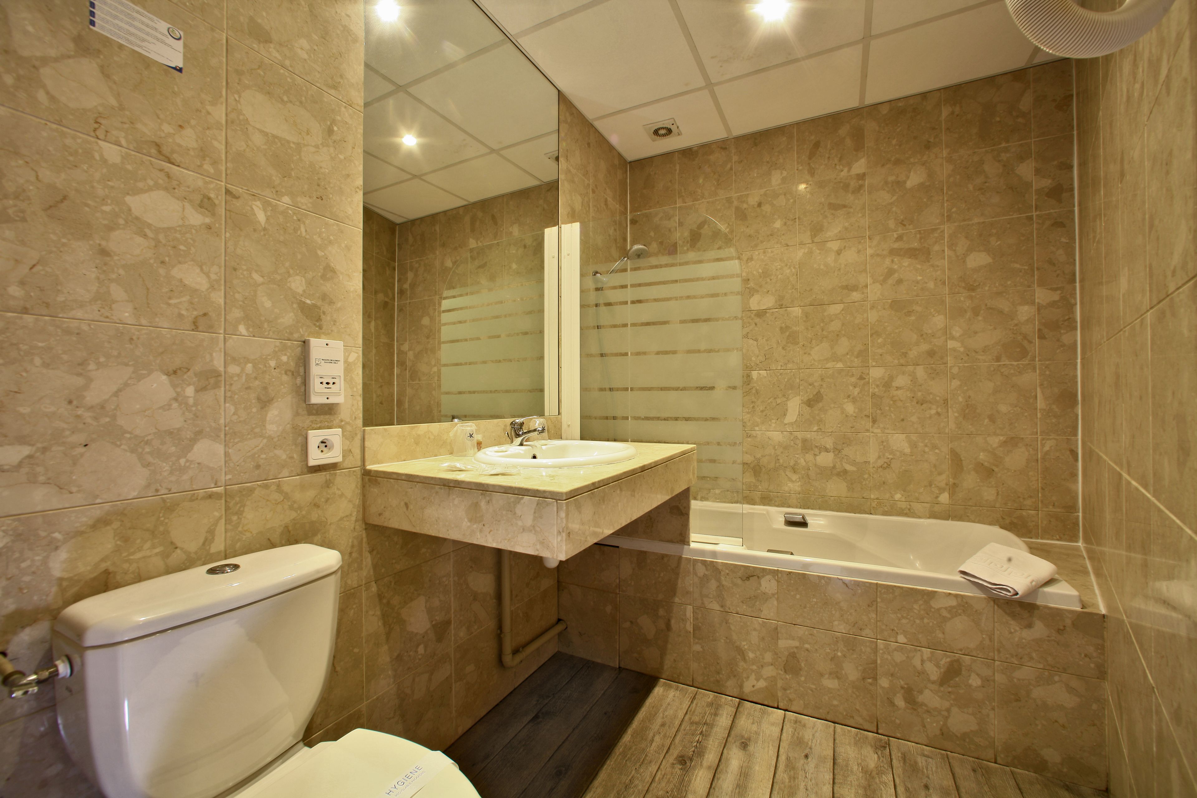 A bathroom with a toilet, sink, and bathtub.