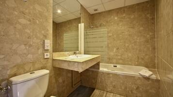 A bathroom with a toilet, sink, and bathtub.