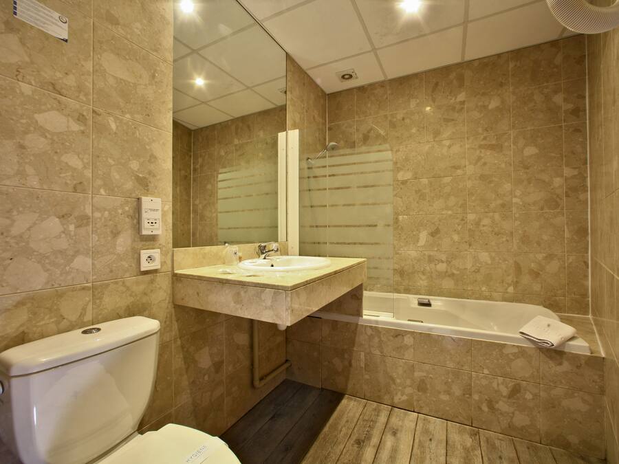A bathroom with a toilet, sink, and bathtub.