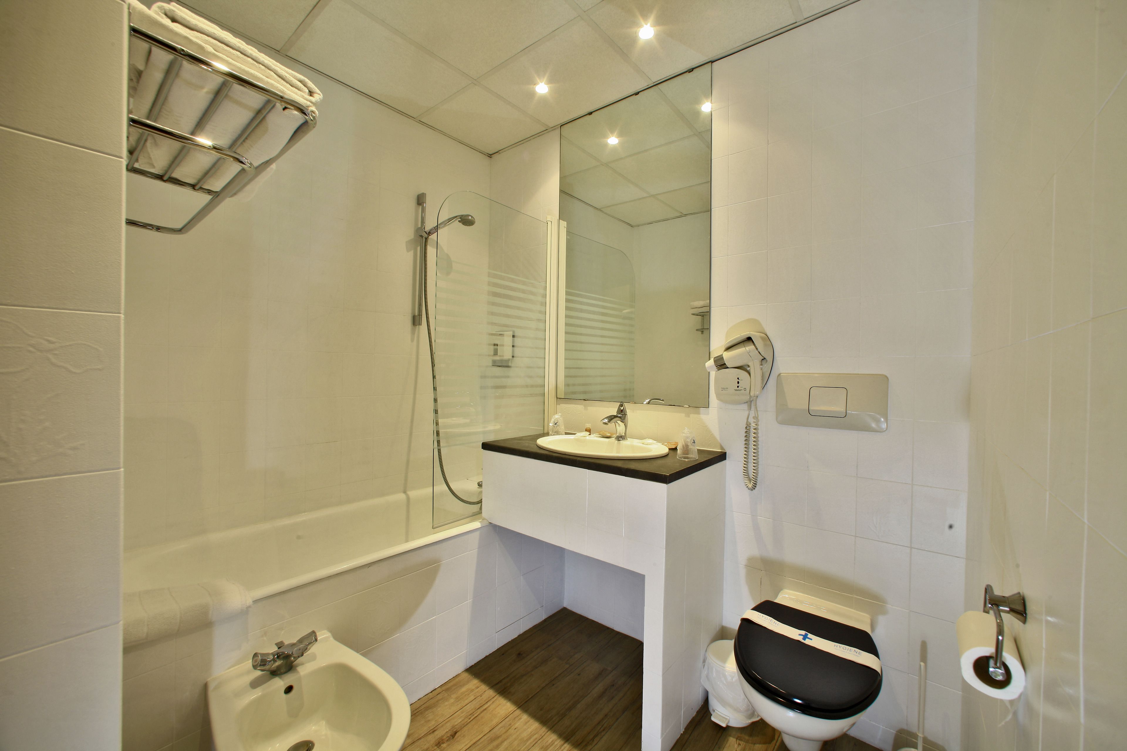 Ein modernes Badezimmer mit Badewanne, Waschbecken, Toilette und Dusche.