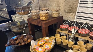 Een buffet met diverse soorten eten, waaronder noten, gedroogd fruit en portie snacks.