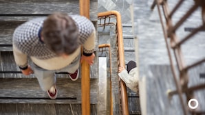 A person climbing a wooden ladder in a modern building with a stone facade. - Center Hotels Skjaldbreið (Reykjavik)