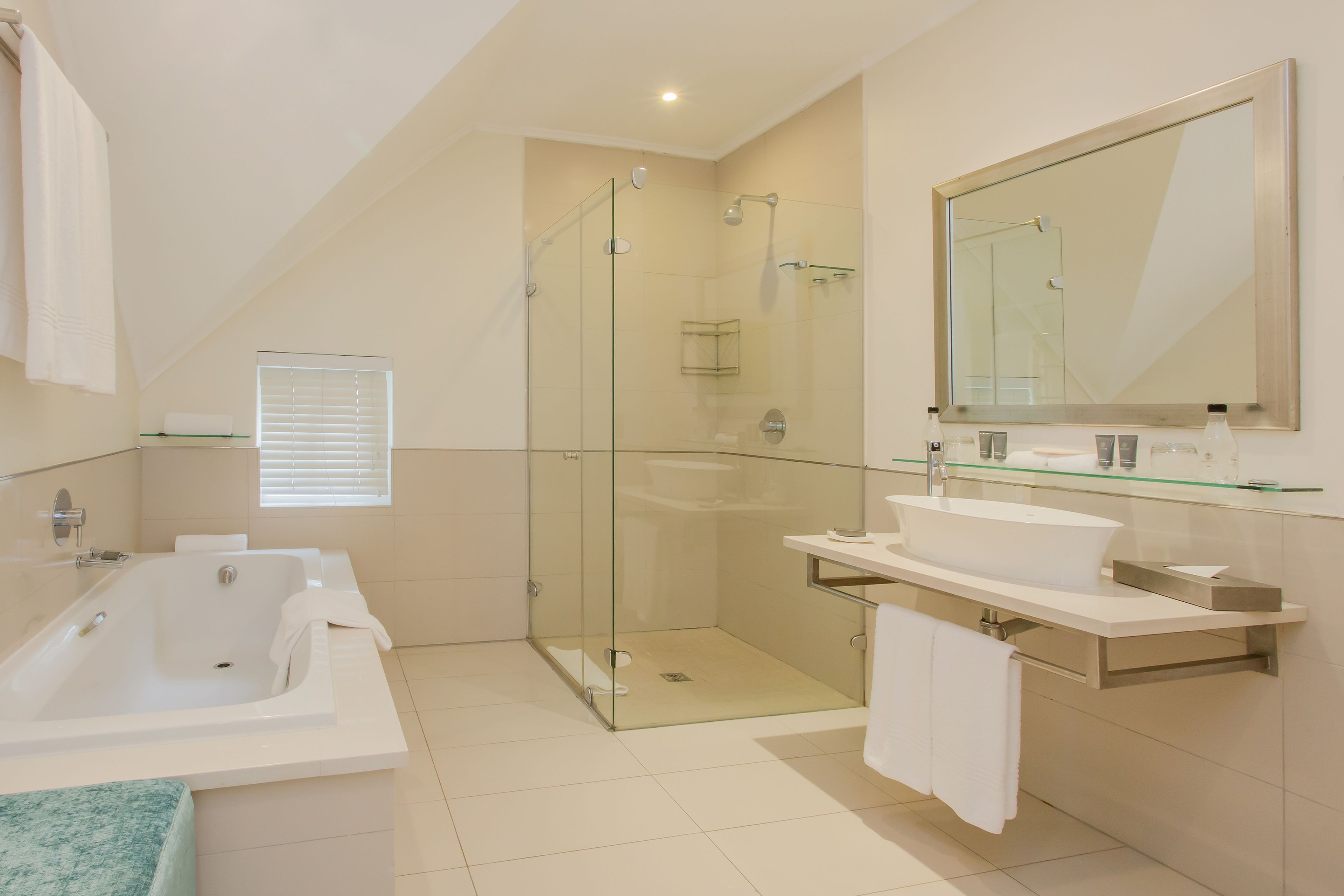 A modern bathroom with a glass-enclosed shower, a freestanding bathtub, and a vanity with a large mirror.