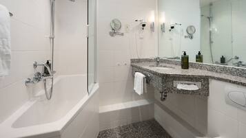 Ein modernes Badezimmer mit Badewanne, Dusche und zwei Waschbecken mit Spiegeln.