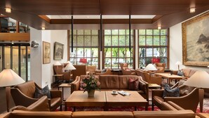 A spacious lobby with leather sofas, tables, and lamps. Large windows offer views of greenery outside. - Hotel Baseler Hof (Hamburg)