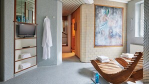 A modern bathroom with a wooden bathtub, a large mirror, and a painting on the wall. - Hotel Central (Hamburg)