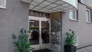 A hotel entrance with a modern design, featuring a glass door and a sign above the entrance. - Hotel Central (Hamburg)