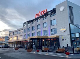 Un hotel con un llamativo letrero que dice 'HOTEL', un restaurante 'KEFLAVIK' y una 'Café' en la planta baja.
