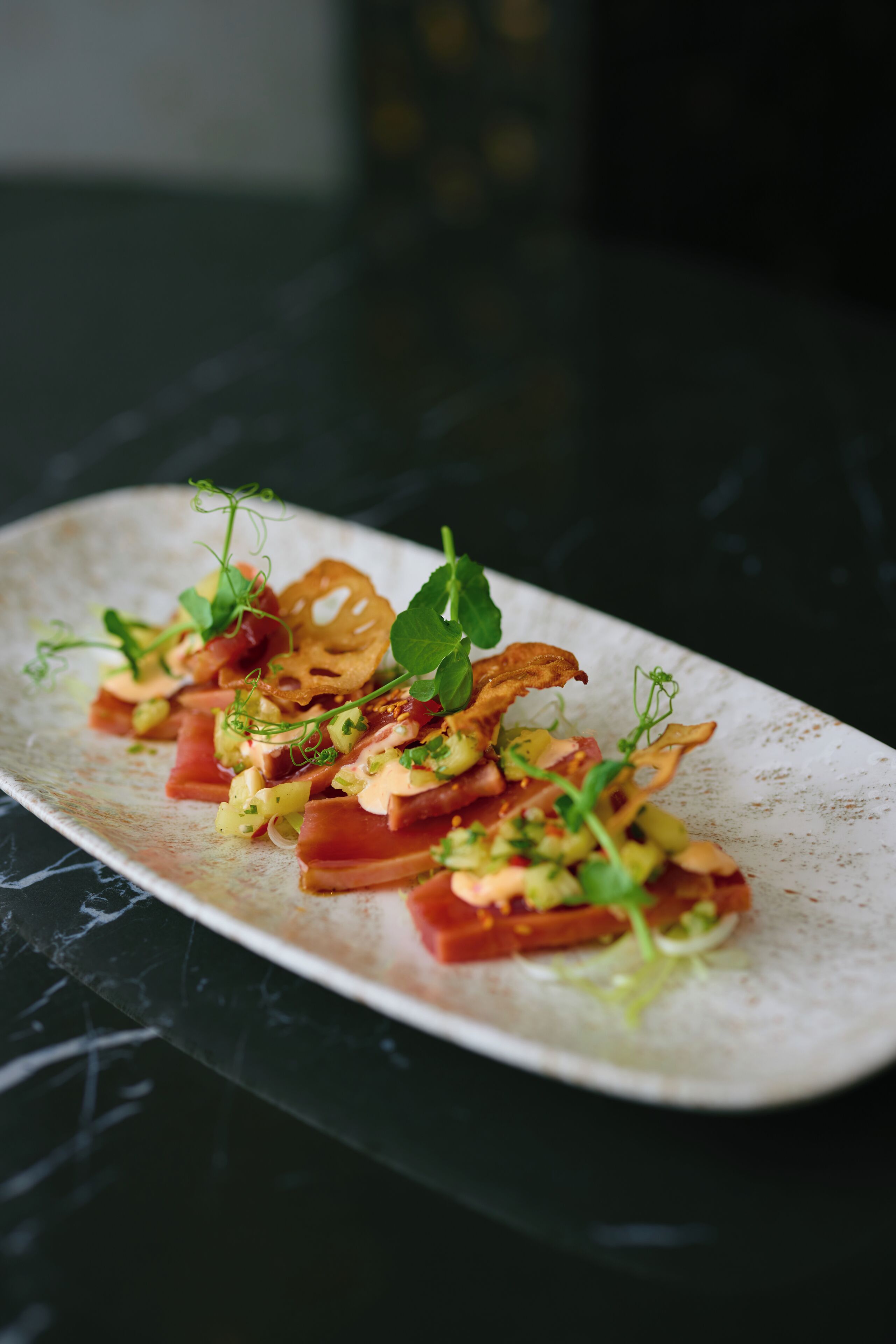A white plate with a food arrangement on a dark surface.