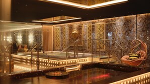 Un espace spa luxueux comprenant un jacuzzi, des sièges et un mur décoratif.