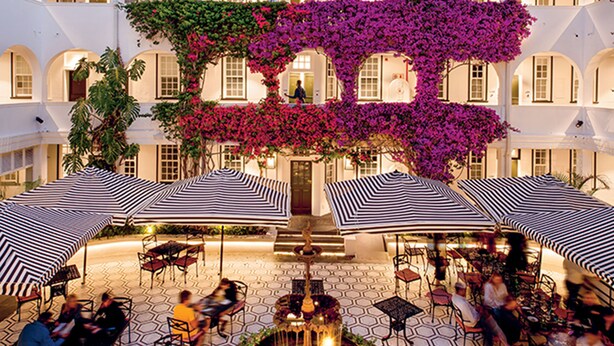 A courtyard with outdoor seating, a central fountain, and a building with arches in the background. - The Winchester Hotel by NEWMARK (Cape Town)