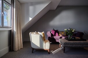 A modern living room with a high ceiling, a sofa, a chair, and a coffee table.