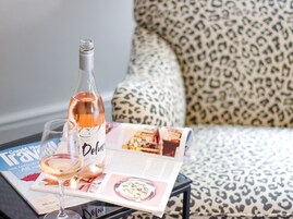 A magazine on a table with a bottle of Delmonte wine and a glass of wine.
