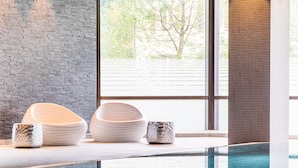 An indoor swimming pool with a clear view of the outdoors through large windows. - Best Western Premier Central Hotel Leonhard (Feldkirch)