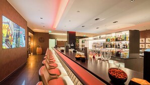 Un espace bar avec des sièges et un présentoir bien garni de boissons alcoolisées.