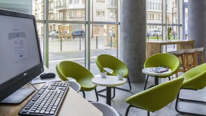 Ein moderner Arbeitsplatz mit Computer, Tastatur und grünen Stühlen.
