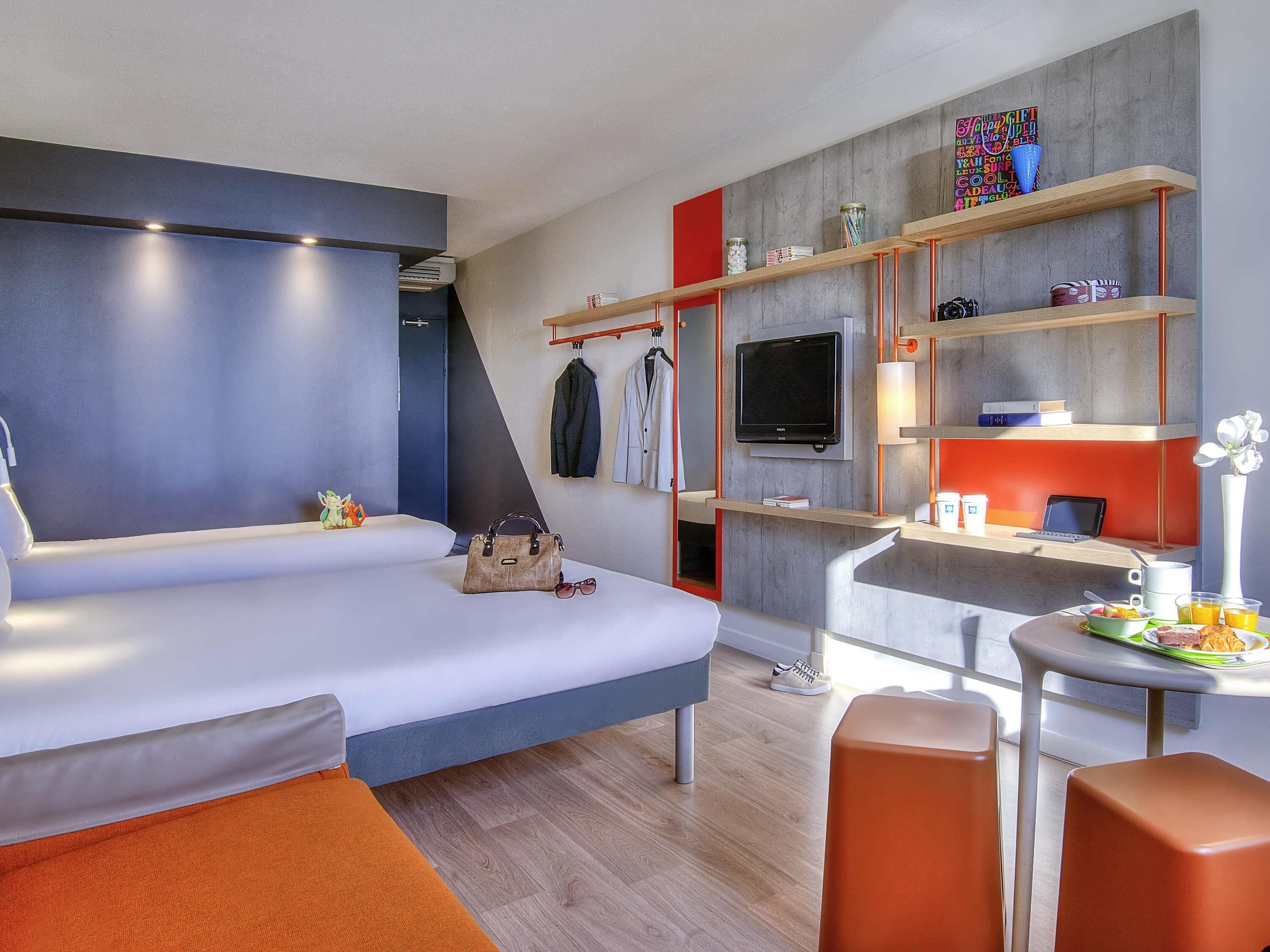 Una habitación de hotel moderna con cama, escritorio y zona de estar.