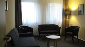 A hotel room with a sofa, two armchairs, a small table, and a lamp. - Dietrich-Bonhoeffer-Hotel (Berlin)