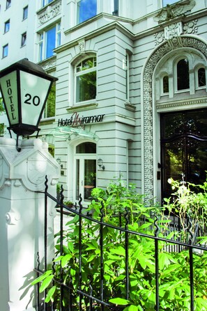 A white building with a sign reading "Hotel Miramar" and a number "20" on a lamp post. - Hotel Miramar (Hamburg)