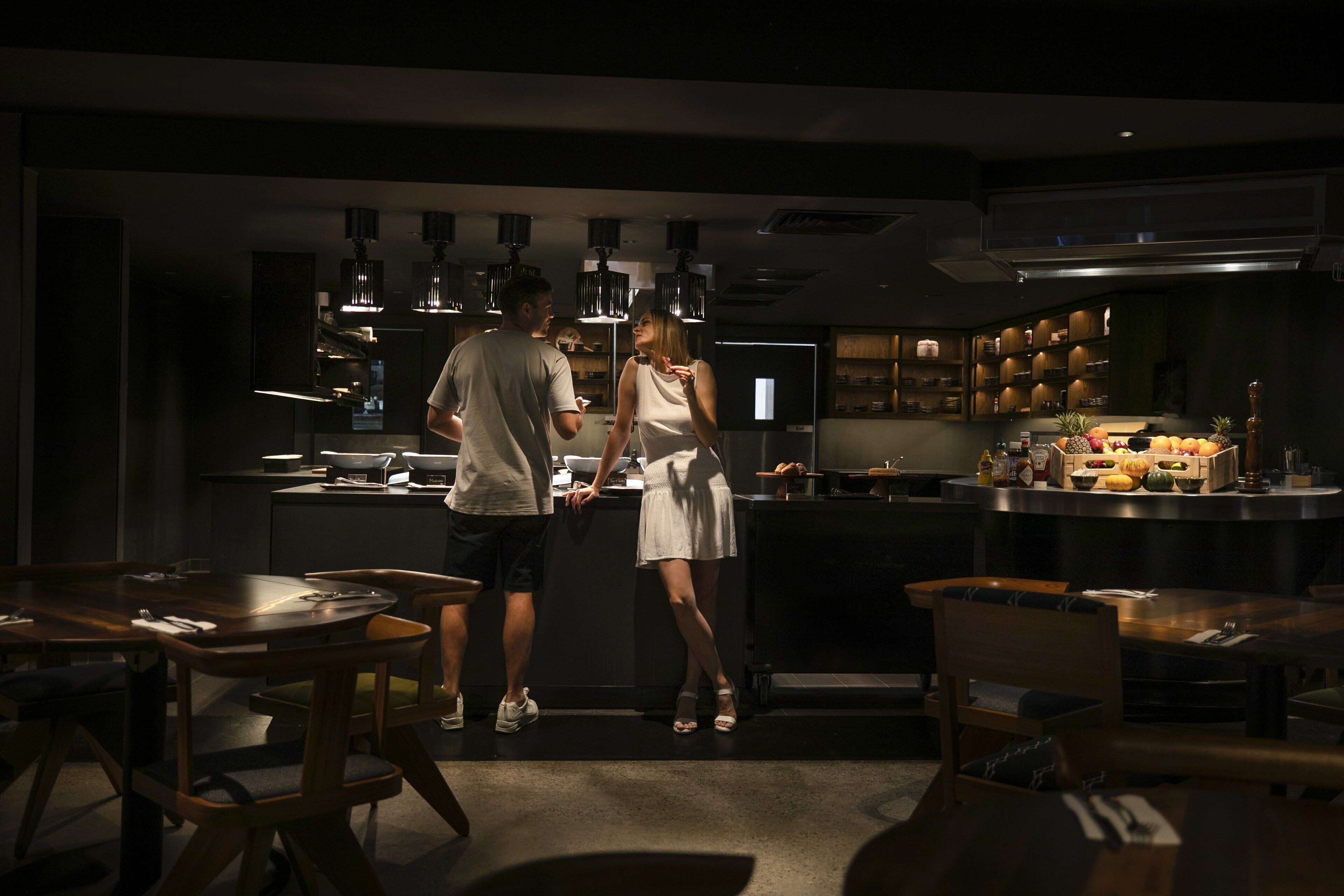 Une cuisine moderne dotée d’un îlot central, de luminaires suspendus et de divers appareils de cuisine.